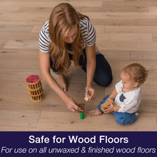 Baby and mother play on wood floor