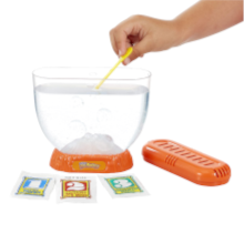 Sea Monkeys Volcano Zoo with lid open and a hand dropping food into the tank. Eggs, water purifier