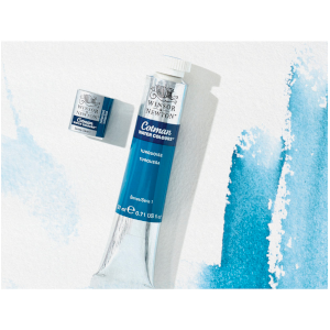 tube and pan of Cotman watercolour paint next to blue brustrokes