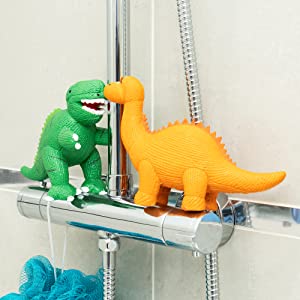 T Rex & Diplodocus Dinosaur bath toys on the taps under a shower head