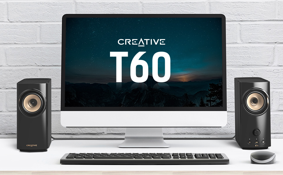 creative t60 2.0 speakers on a desktop beside monitor and pc set up