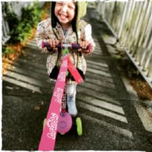 Young girl riding the pink trunki scooter