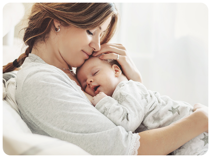 mother holding happy sleeping baby with no cradle cap after baby cradle cap shampoo treatment