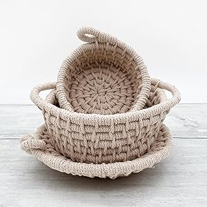 three coasters on a desk, one with a cup of tea, one with a plant, one just on its own