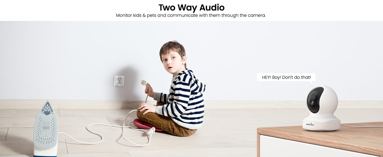 Child in striped shirt using a white, cube-shaped device on table. Larger white device with camera visible nearby.