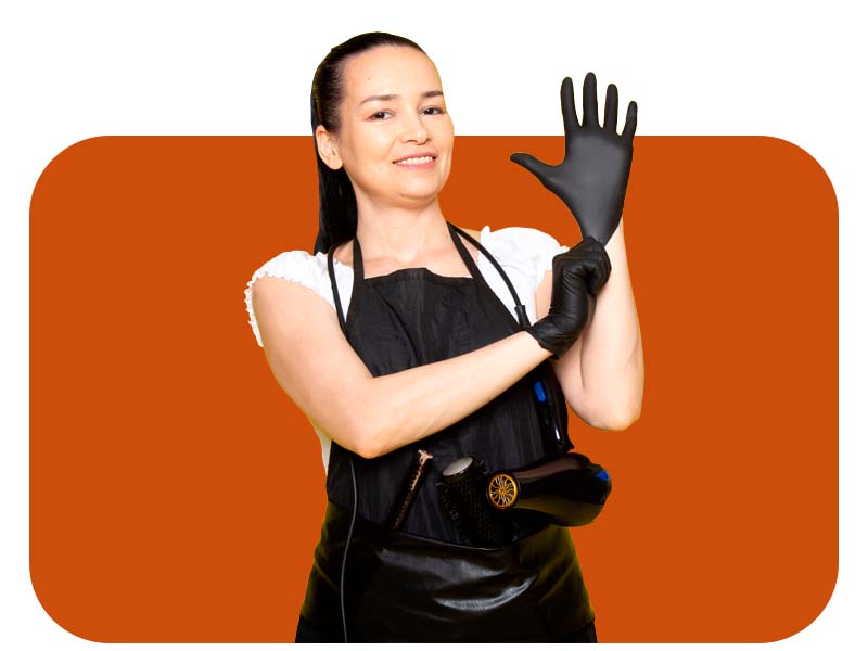 Orange cleaning glove being used to wipe down a gray car interior surface or upholstery.