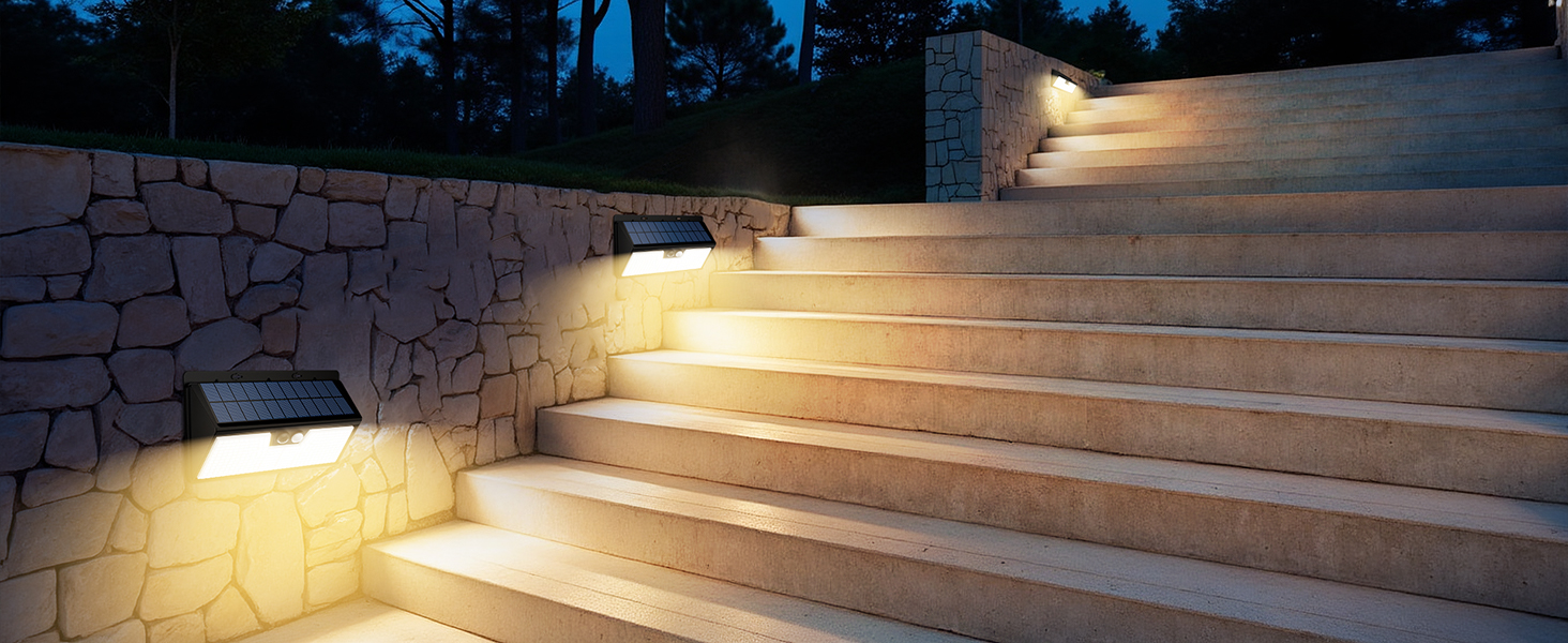 Outdoor stone steps illuminated by warm LED wall lights, creating ambient lighting along the stairway at night.