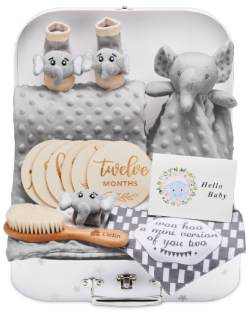 Baby gift set featuring plush animal toys, wooden milestone cards, a brush, and other baby accessories in a suitcase-style box.