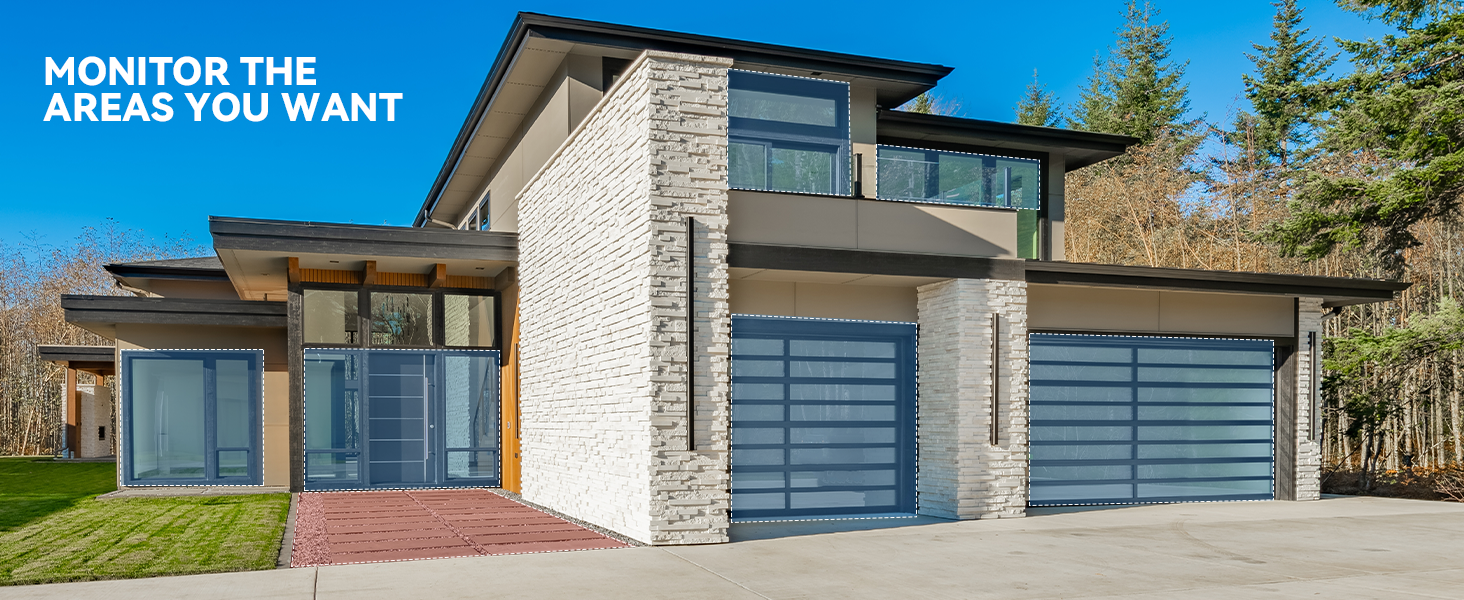 Text reads 'MONITOR THE AREAS YOU WANT'. Modern luxury home exterior with stone facade and three garage doors.