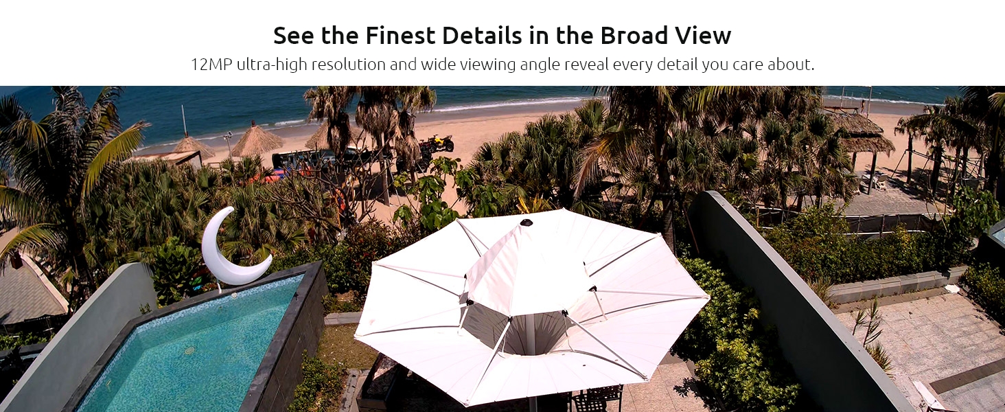 Aerial photograph showing a large white umbrella-style canopy next to a swimming pool, surrounded by palm trees at sunset.