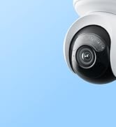White wireless security camera with antenna mounted against light blue background, with partial text visible showing 'Recording Camera'