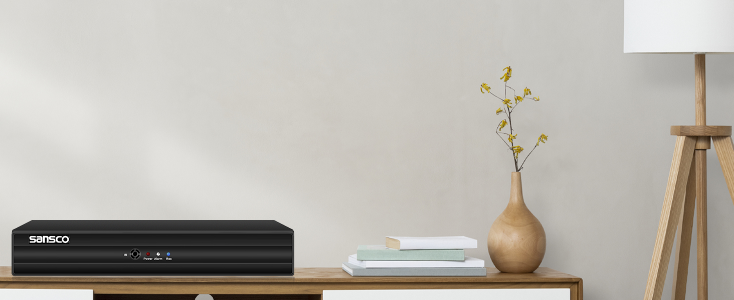 a black box on a table next to a vase with flowers.