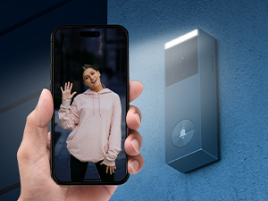 Portable LED light device shown illuminating a person's face for a smartphone photo. Device appears compact and attachable to phone.