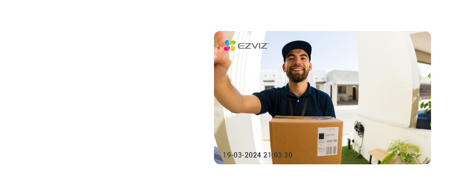 Delivery service worker holding up cardboard package in front of white wall with shipping label visible.