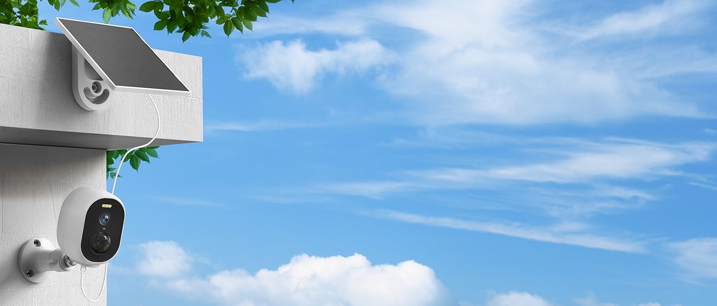 Security camera mounted on white exterior wall corner, with blue sky and wispy clouds in background.