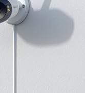 Black cylindrical security camera with dual lenses mounted on a white surface, positioned against a clear blue sky background.
