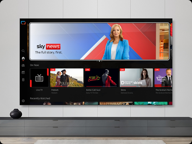 Sky News streaming interface displayed on tablet screen showing live news broadcast with woman presenter in blue jacket against red background, below are thumbnail video content tiles in dark interface layout.