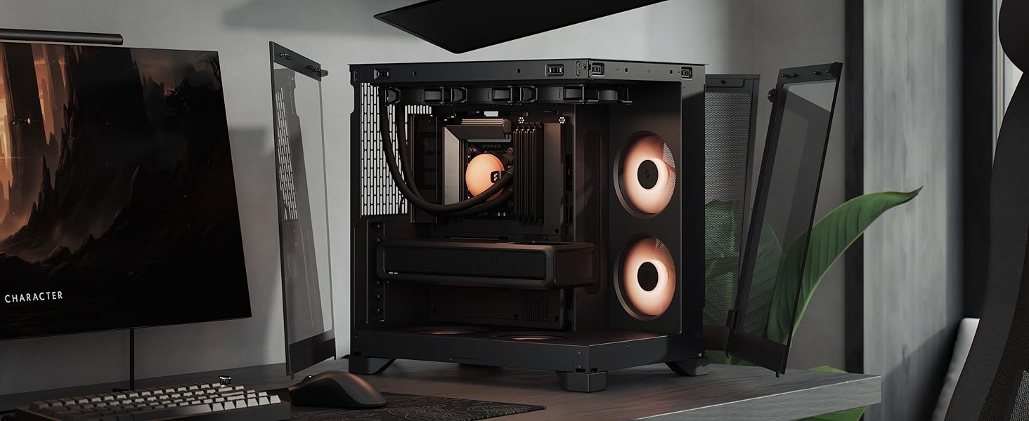 Desktop gaming setup featuring black PC tower case with orange and white circular ventilation details, positioned on desk with monitor, keyboard, and peripherals visible.