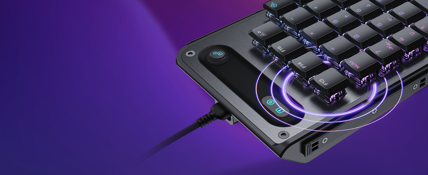 Gaming keyboard with black keys and purple LED backlighting on dark background, USB cable visible, angled view showing mechanical key design and illumination.