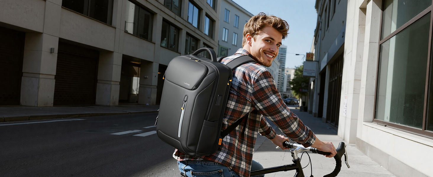 Man wearing brown plaid shirt and gray backpack with shoulder straps, carrying bicycle on urban street with modern buildings. Backpack demonstrates practical carrying capacity and ergonomic design.
