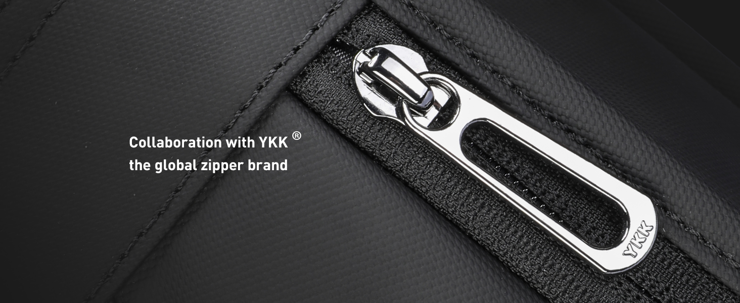 Close-up of black fabric material with zipper or fastening detail, showing technical construction features.