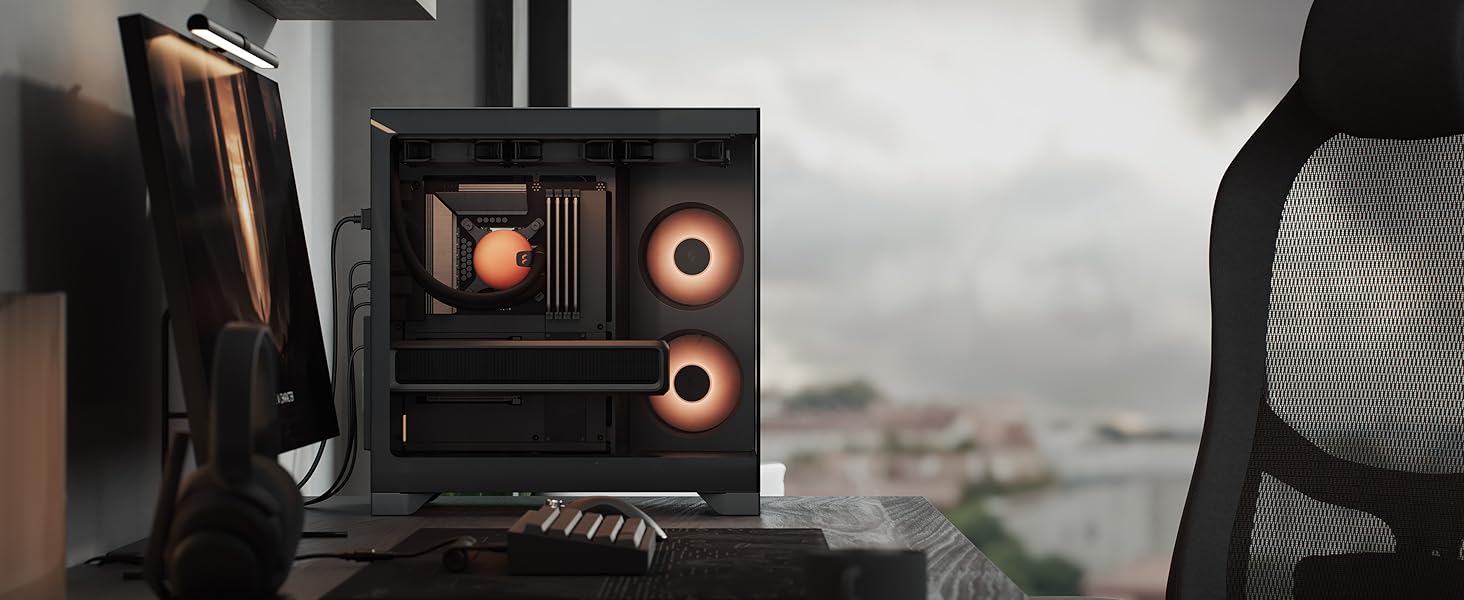 Black desktop speaker system with orange accents positioned on desk near computer keyboard and mouse. Compact multimedia speakers with visible front-facing drivers.