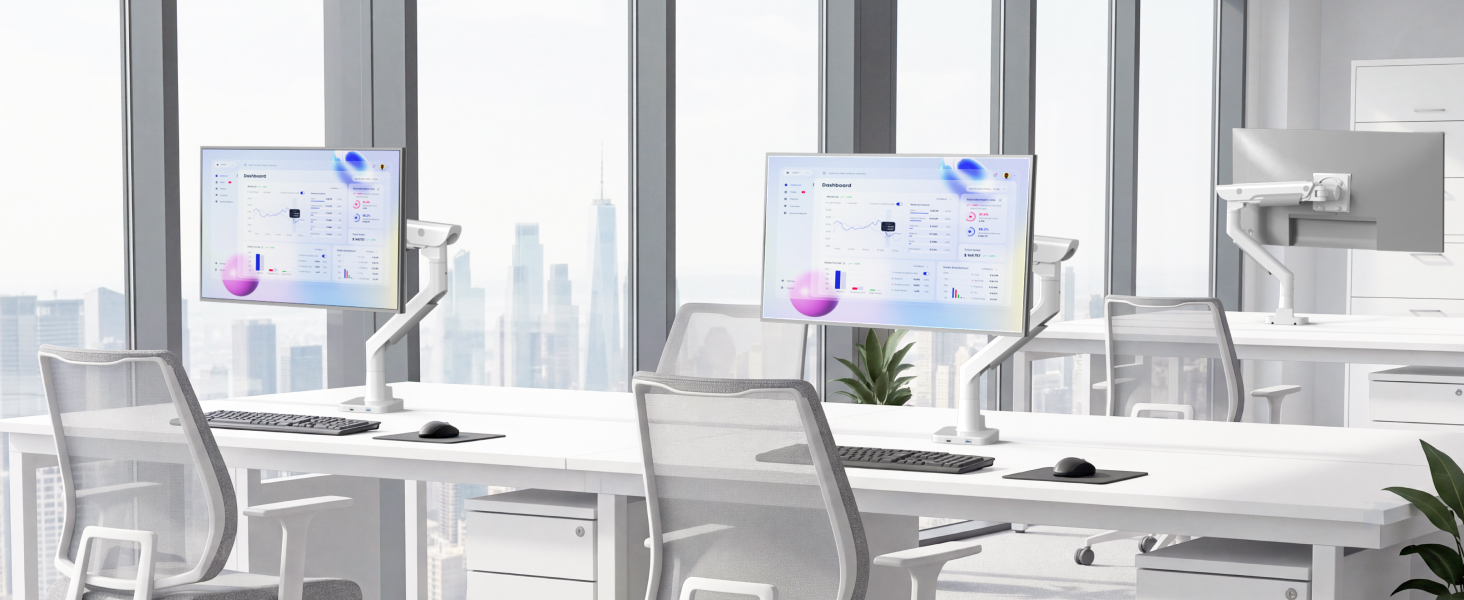 Modern office workspace interior showing two computer monitors on desks with plants, white chairs, and city skyline visible through windows in bright minimalist setting.