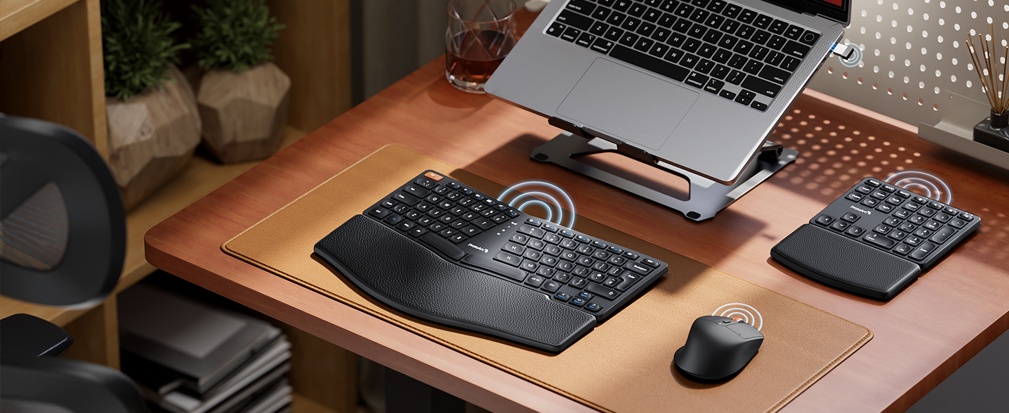 Ergonomic desk setup with laptop stand, split keyboard, numeric keypad, and mouse on a wooden desk surface. Laptop elevated for improved viewing angle.