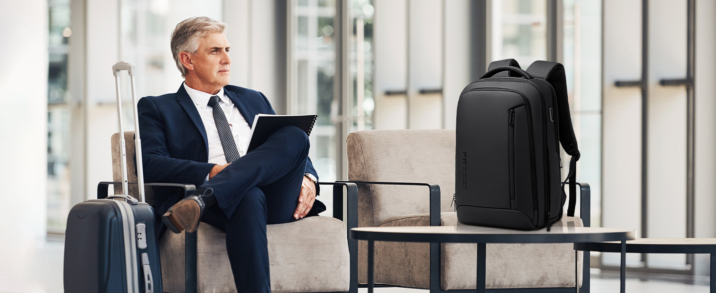 Black professional business backpack displayed next to waiting area seating.