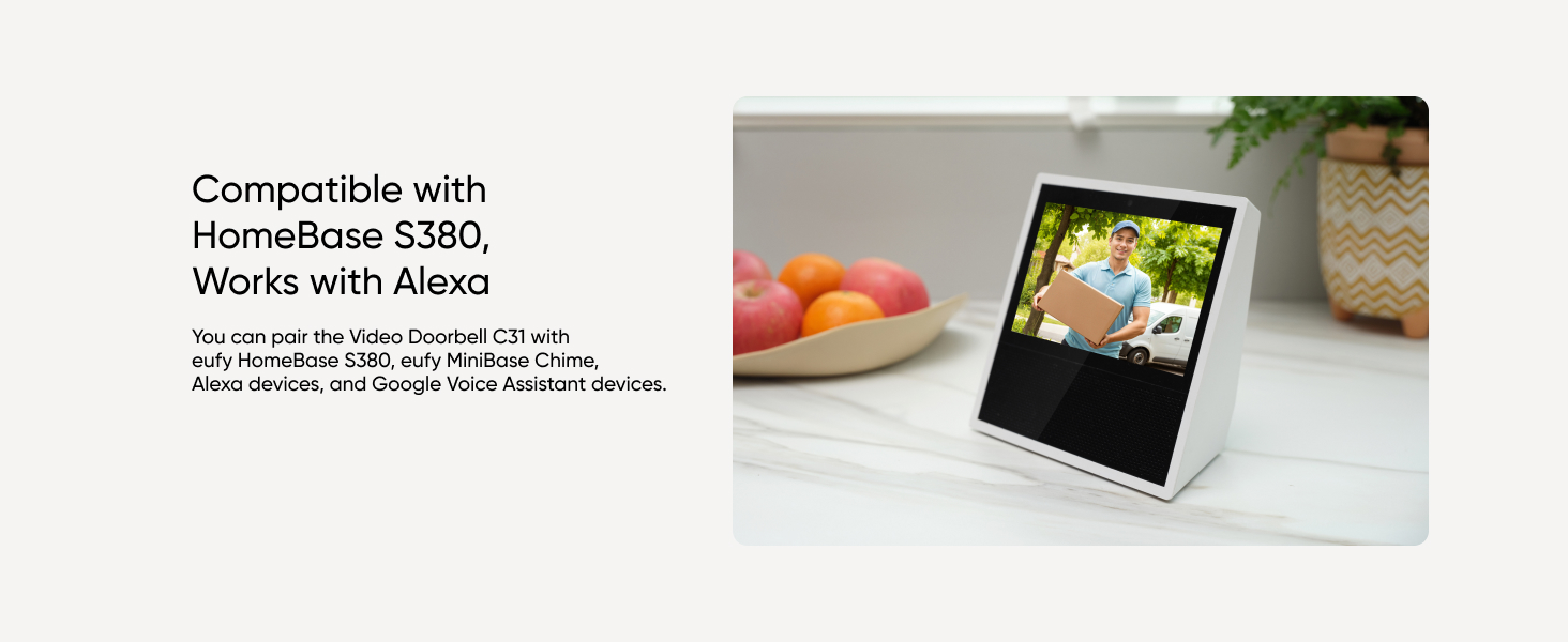 Smart display device showing colorful interface. Text indicates compatibility with HomeBase S380 and Alexa. Fruits visible in foreground.