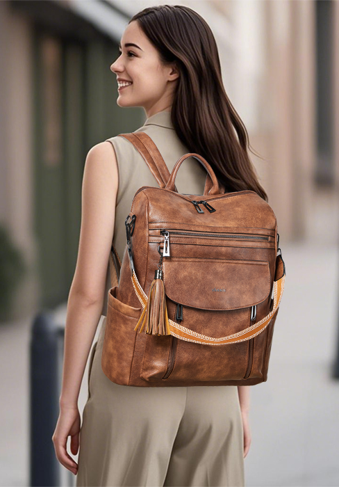 Woman wearing cognac brown leather backpack with dual straps, front pockets, and buckle details over casual beige outfit, shown in side profile against blurred architectural background.