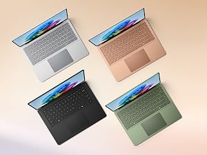 Open laptop displaying dual screens with colorful rainbow gradient design and digital imagery, shown against beige background.