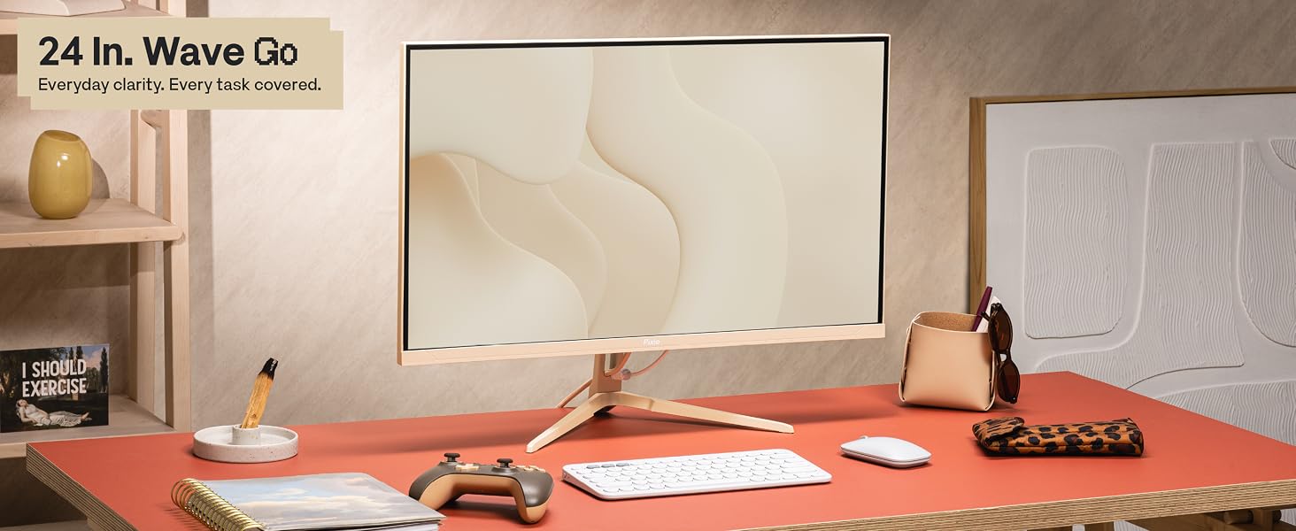 Text reads '24 In. Wave Oo'. Beige minimalist workspace desk setup with monitor, decorative items, and red/orange desk accessories arranged on coral-colored surface.
