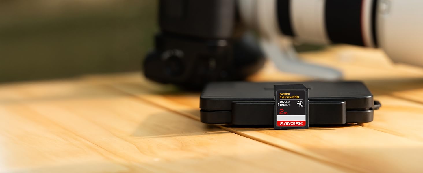 Close-up view of camera equipment on wooden surface, showing a black electronic device or adapter.