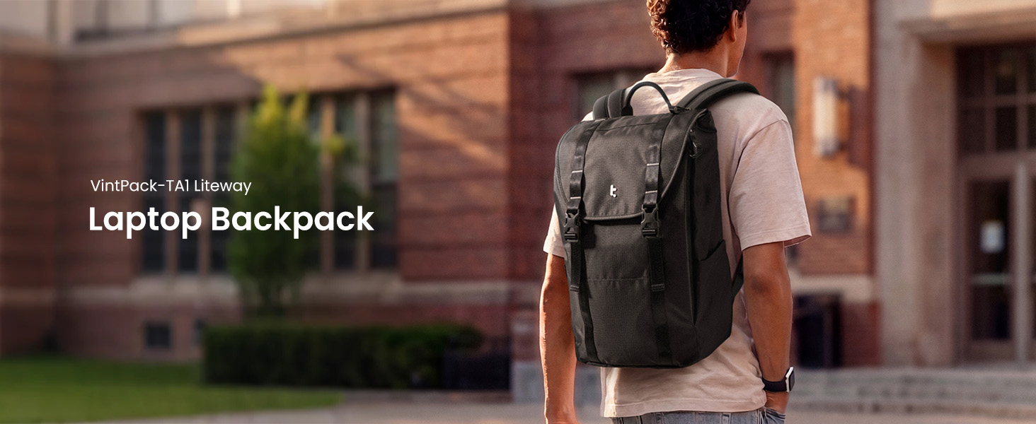 Text reads 'Laptop Backpack'. Man wearing dark backpack with laptop compartment standing outdoors against brick building wall.