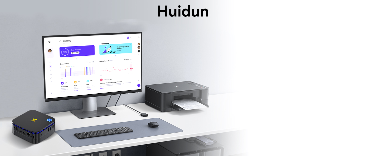 Desktop computer setup with monitor displaying data graphs, small black device, keyboard, and printer stand. Clean, minimalist workspace on white surface against gray background.