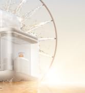 White robot vacuum cleaner with circular design showing control buttons, positioned near decorative wire wheel on light surface.