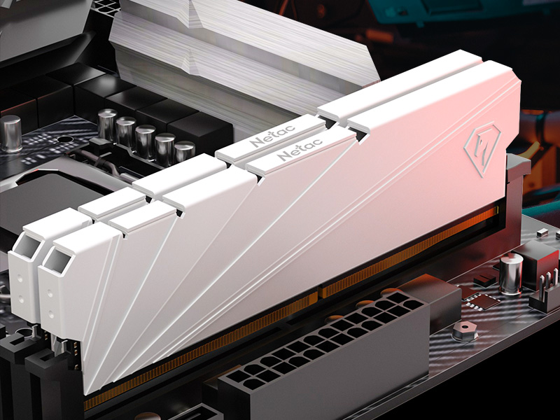 Two white computer RAM sticks with metallic contacts, lying on a colorful RGB backlit keyboard. The RAM modules have heat spreaders with patterns.