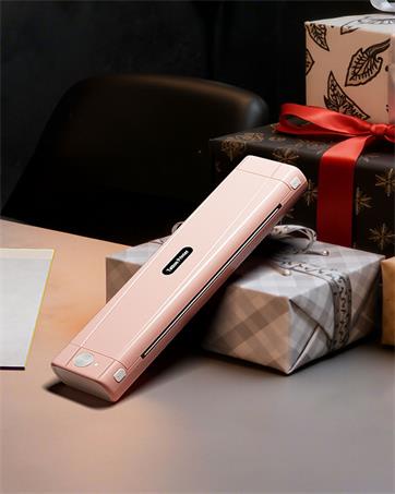Rose gold or pink metallic electronic device or trimmer shown on dark surface next to wrapped package.