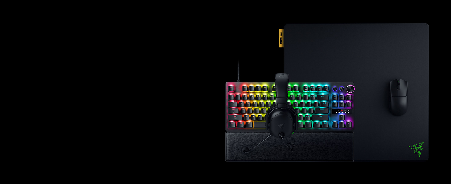 Gaming keyboard with RGB rainbow backlighting displayed against dark background, with what appears to be a gaming mouse visible on the right side