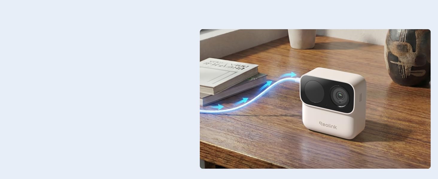 Compact white portable projector positioned on wooden surface next to laptop. Device displays projected image on wall, demonstrating compact projection capability for workspace presentations.