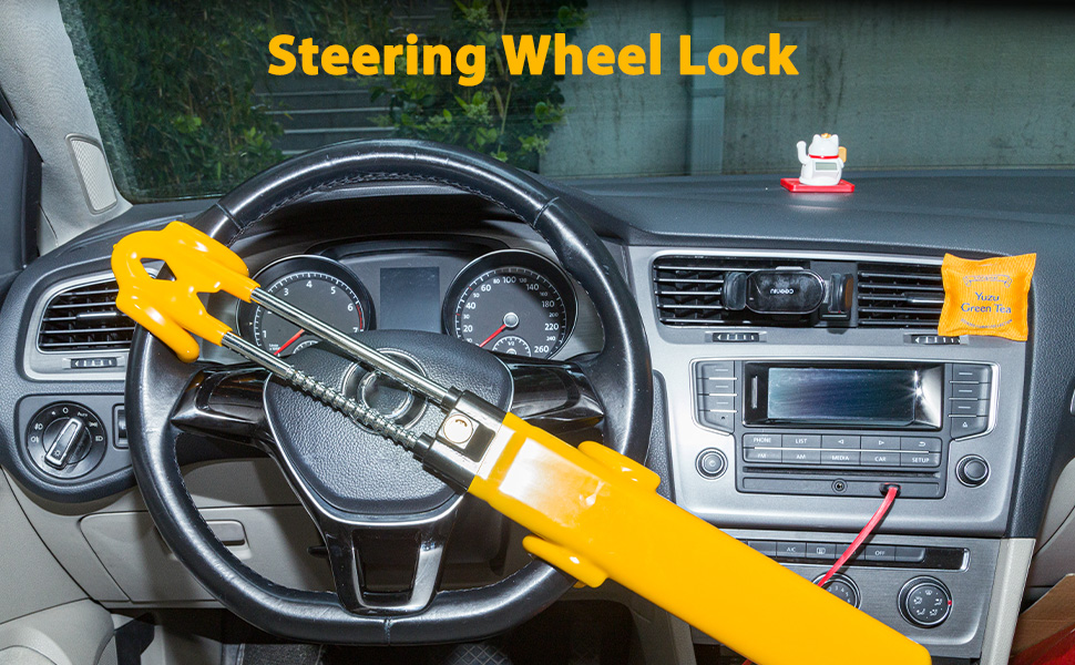 Text reads 'Steering Wheel Lock'. Yellow anti-theft device clamped across vehicle steering wheel inside car interior.